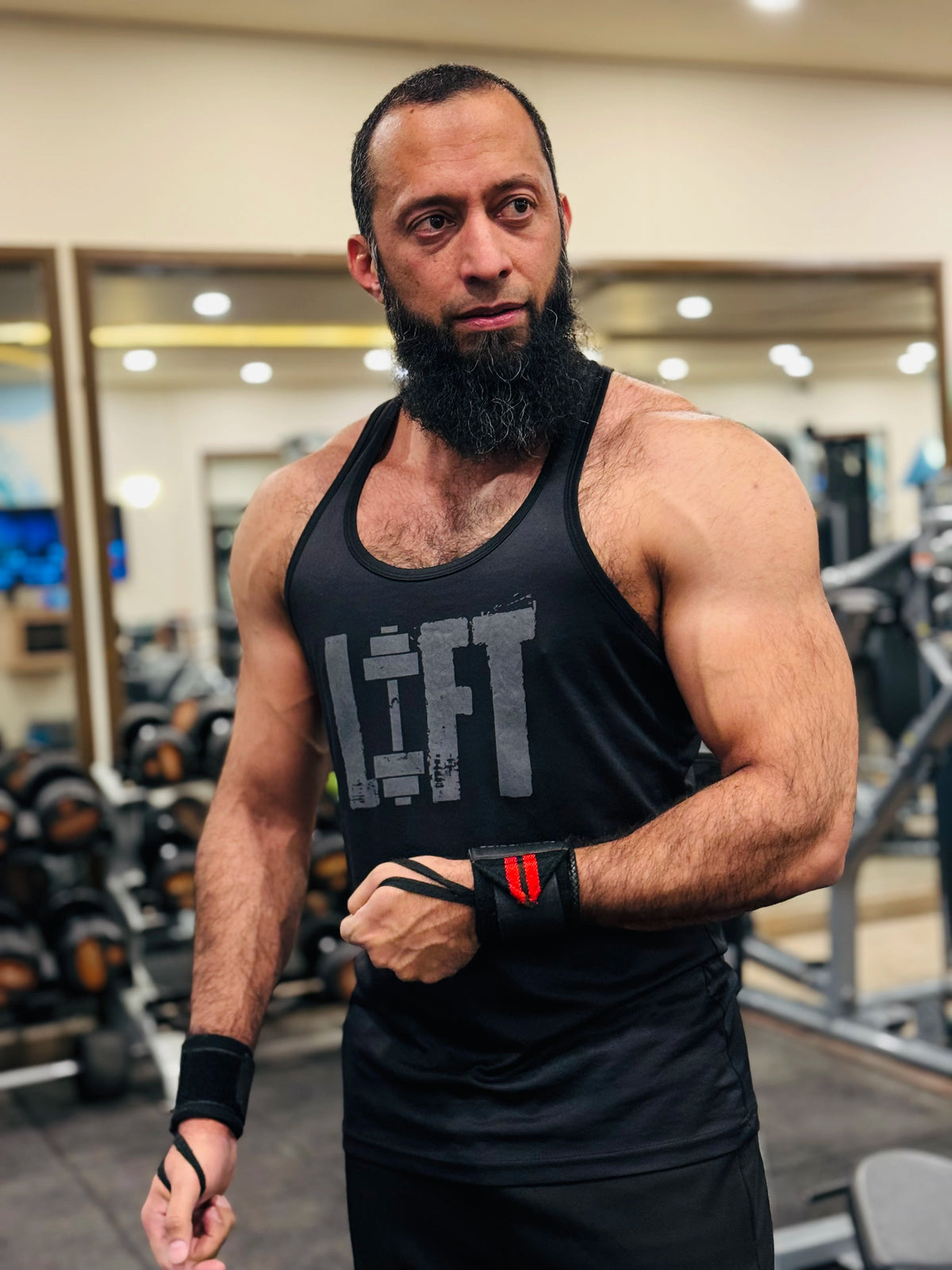BIOVAQ founder in a gym wearing a black tank top with "LIFT" printed on it.